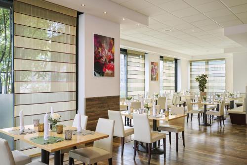 オーバーハウゼンにあるNHオーバーハウゼンのテーブルと白い椅子のあるダイニングルーム