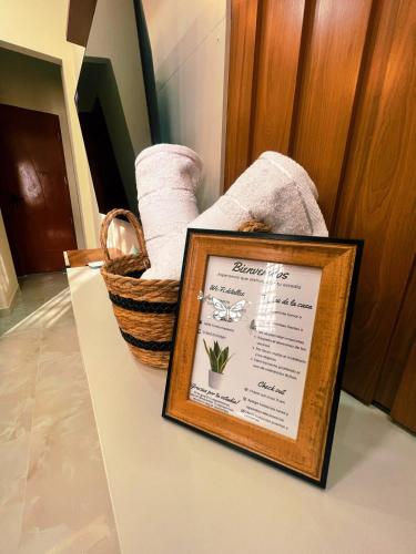 a framed picture on a counter next to a basket of towels at Exclusive and Central Studio Apartment in Trinidad