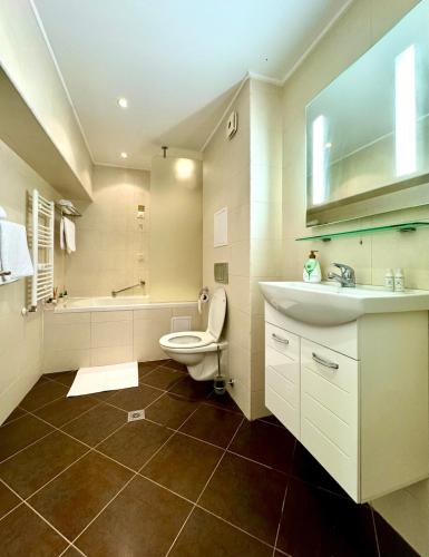 a bathroom with a toilet and a sink and a tub at SPA Apartment Alex in Borovets