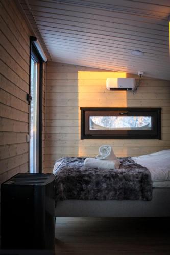 a bedroom with a bed in a wooden wall at Palas Experience Olkkajärvi Resort in Rovaniemi