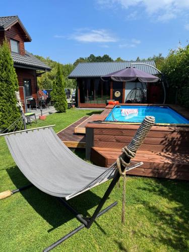 een hangmat in een tuin naast een zwembad bij Redwood Mielno in Mielno