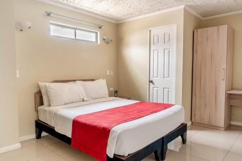 een slaapkamer met een bed waarop een rode deken ligt bij Hotel Veas in Antofagasta