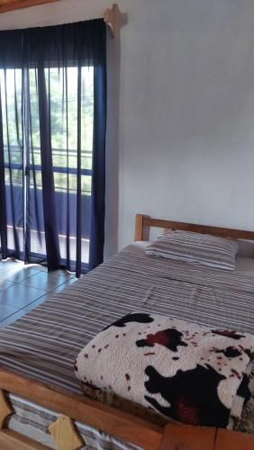 un letto in una camera con finestra e coperta di Fede lll a Eldorado