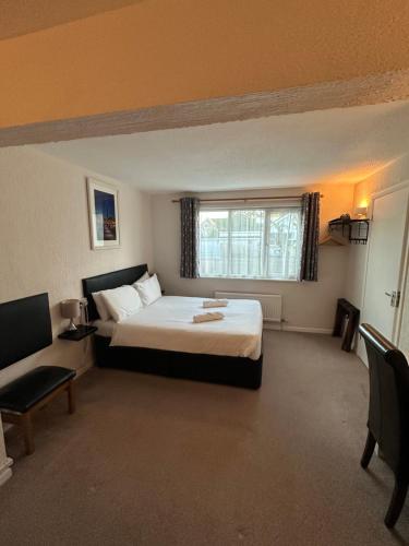 ein Hotelzimmer mit einem Bett und einem Fenster in der Unterkunft Capri Guest House in Torquay