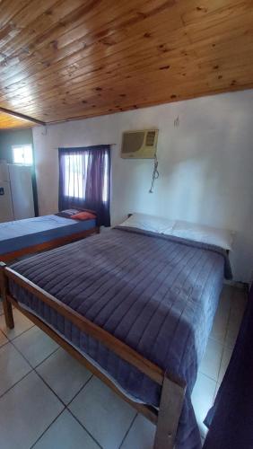 a large bed in a room with a wooden ceiling at Fede lll in Eldorado