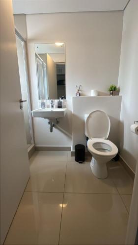 Umhlanga Millenial Deluxe في ديربان: حمام مع مرحاض أبيض ومغسلة
