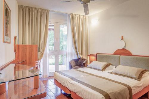 a bedroom with a bed and a glass table at Residence Riva degli Etruschi in San Vincenzo