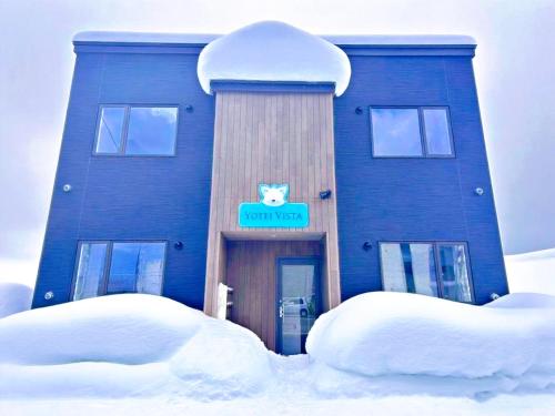 a blue building with a cat sign on it in the snow at Niseko Yotei Vista in Kutchan