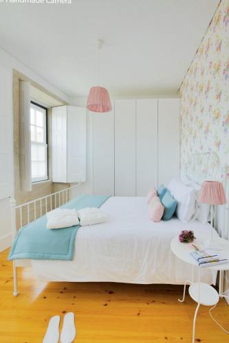 a bedroom with a large bed with blue and pink pillows at Charming Apartments in Historic Centre - Inside Porto Apartments "Flores" in Porto