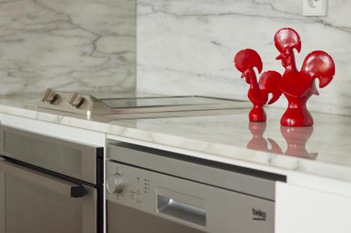 a kitchen counter with red figurines on top of it at Charming Apartments in Historic Centre - Inside Porto Apartments "Flores" in Porto