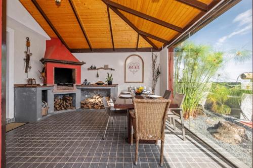 an outdoor patio with a table and a fireplace at São Jorge Cottage - By WeHost in Santana