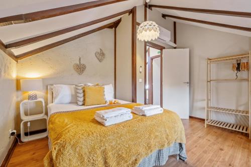 a bedroom with a large bed with towels on it at São Jorge Cottage - By WeHost in Santana