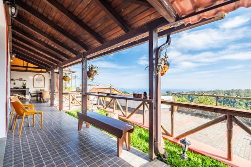 a view from the deck of a house with a bench at São Jorge Cottage - By WeHost in Santana