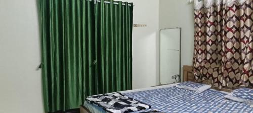 um quarto com uma cama e uma cortina de chuveiro verde em Junglee Valley Holiday Home em Mahabaleshwar