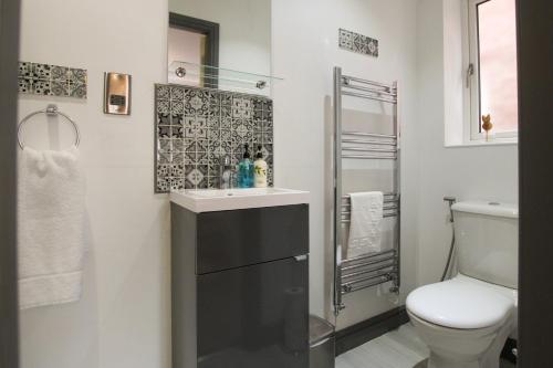 a bathroom with a sink and a toilet at Modern 3-Bedroom Home in Quiet Cul-de-Sac w Parking by Rework Accommodation in Saltney