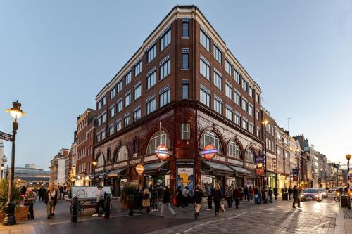a group of people walking on a street in front of a building at Elegant 2 Bed and 3 Bath Apt in the Heart of Covent Garden ZONE 1 in London