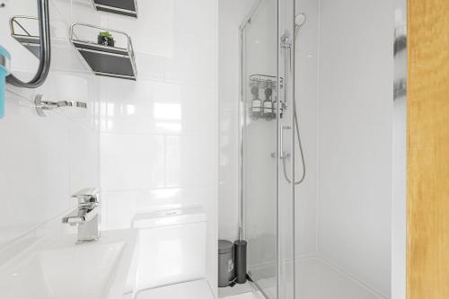 a white bathroom with a shower and a sink at Elegant 2 Bed and 3 Bath Apt in the Heart of Covent Garden ZONE 1 in London