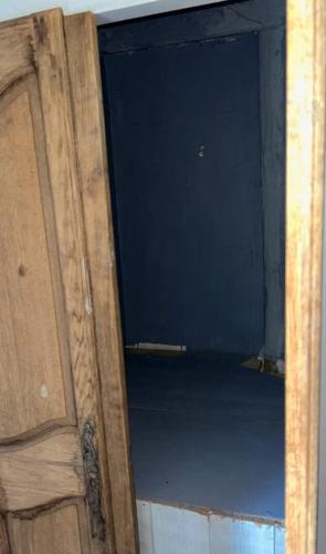 Una puerta abierta de una habitación con un armario de madera. en Chambre privée au bord de la rivière, 