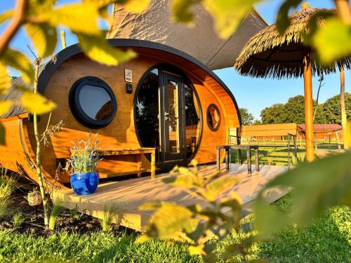 a dome shaped house with a deck and a table at Magnolia Hoeve - Unieke Bestemming voor Paardenliefhebbers en Bijzondere Overnachtingen in de natuur in Ledeacker