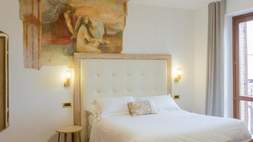 a bedroom with a bed with a painting on the wall at Relais Madonna di Campagna in Bastia Umbra