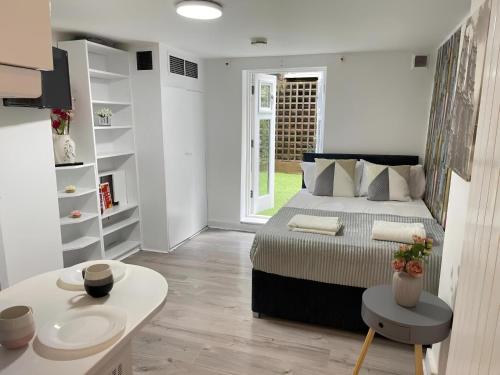 a bedroom with a bed and a table in it at Portobello Road Artistic Studios in London