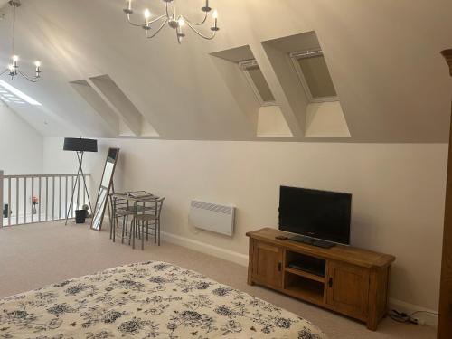 a bedroom with a bed and a flat screen tv at Charming King Bed Ensuite Studio in Peaceful West Challow in Wantage