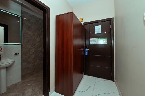 bagno con porta in legno e lavandino di فندق رفاهية الكرام a Al Khansāk