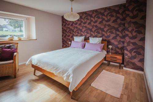 a bedroom with a large bed with pink pillows at Im Prummehuck in Raeren