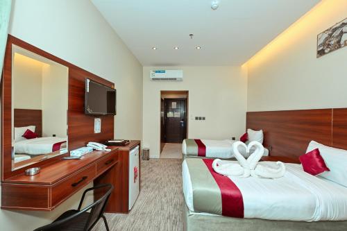 una camera d'albergo con due letti e uno specchio di فندق رفاهية الكرام a Al Khansāk