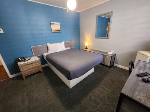 a hotel room with a bed and a table at Motel Le Victo in Victoriaville