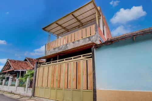 um edifício com portas de garagem de madeira em uma rua em OYO 94920 House Of Elea Minggiran em Timuran