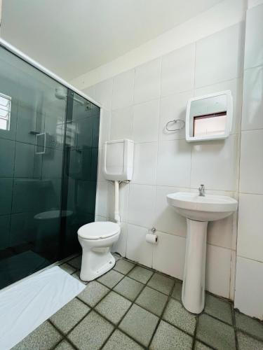 a bathroom with a toilet and a sink and a shower at Hotel Transbrasil in Belém