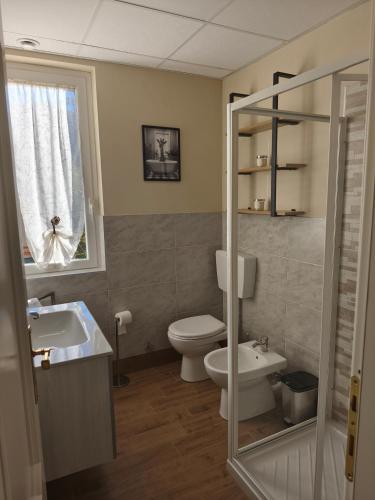 a bathroom with a toilet and a sink and a window at Ca' da Lisa in San Colombano Certenoli