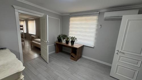 奇姆肯特Hostel Miras的一间卧室配有一张床和一张桌子,两棵植物