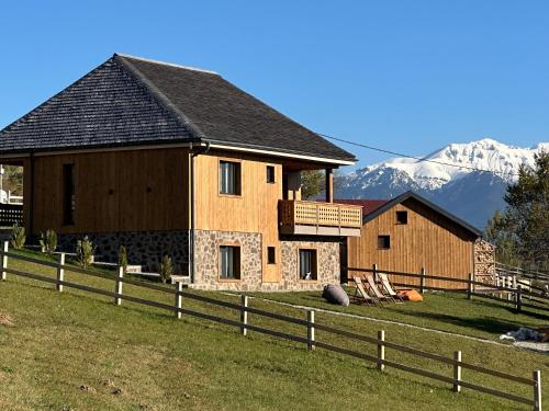 uma casa com uma cerca e montanhas ao fundo em Vatra Chalet em Măgura
