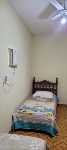 a bedroom with a bed with a fan and a tv at Casa 2 quartos com ar condicionado e próximo ao centro in Cachoeiro de Itapemirim