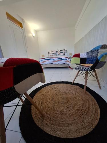 a living room with two chairs and a rug at Logement chaleureux confortable - 2 chambres - Aveline in Petit-Canal