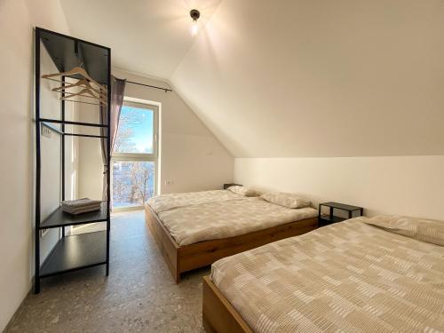 Un dormitorio con dos camas y una ventana. en KOČA ODMEV Obolno, en Ivančna Gorica