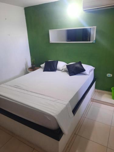 圣玛尔塔Hostal Santa Maria City的绿色墙壁间的一张床位