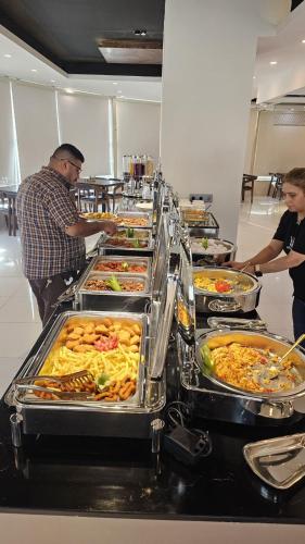 Una línea de buffet con muchos tipos diferentes de comida. en Erbil Platinum Hotel, en Erbil