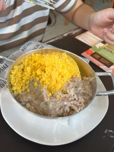 a bowl of food on a plate on a table at Manaíra Apart Hotel in João Pessoa