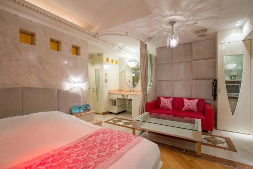 a bedroom with a red bed and a red couch at HOTEL AN Shinjuku Kabukicho (Adult Only) in Tokyo