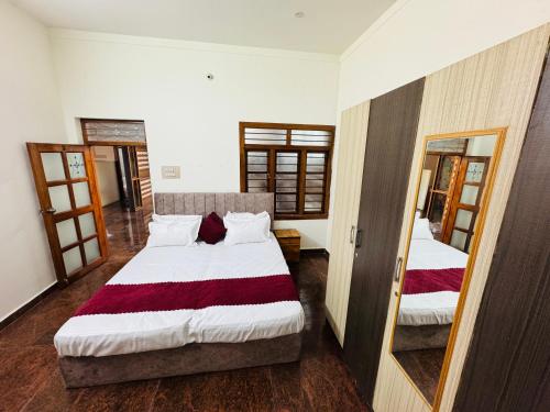 a bedroom with two beds and a mirror at Rooms in appartment by LUXE in Mysore