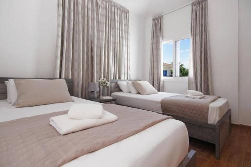 ein Schlafzimmer mit zwei Betten und einem Fenster in der Unterkunft Elite Luxury Villa in Paralimni
