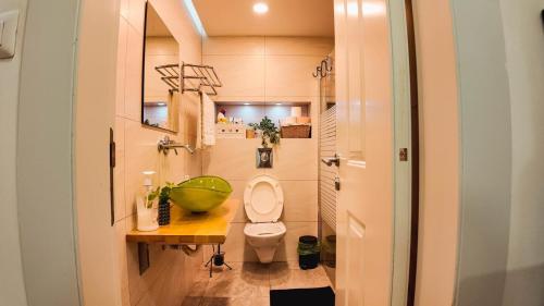 baño pequeño con aseo y mesa de madera en Leo Apartment by the sea Eilat, en Eilat