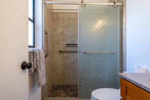 een badkamer met een glazen douche met toilet bij Hono Kai Resort C9 in Wailuku