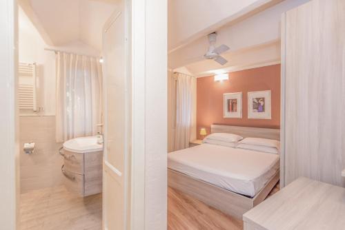 a small bedroom with a bed and a bathroom at Resort Riva Degli Etruschi in San Vincenzo