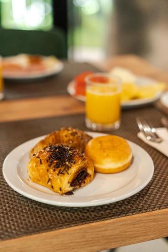 a plate of food with bread and orange juice on a table at Sercotel Princesa De Eboli in Pinto