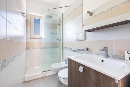 a bathroom with a sink and a toilet and a shower at Attico Mezzaluna by BarbarHouse in Torre Santa Sabina