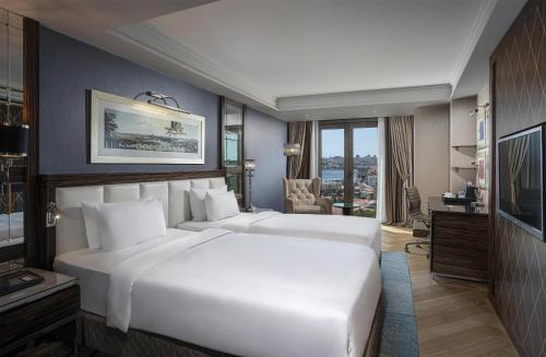 a hotel room with two beds and a television at Radisson Blu Hotel Istanbul Pera in Istanbul